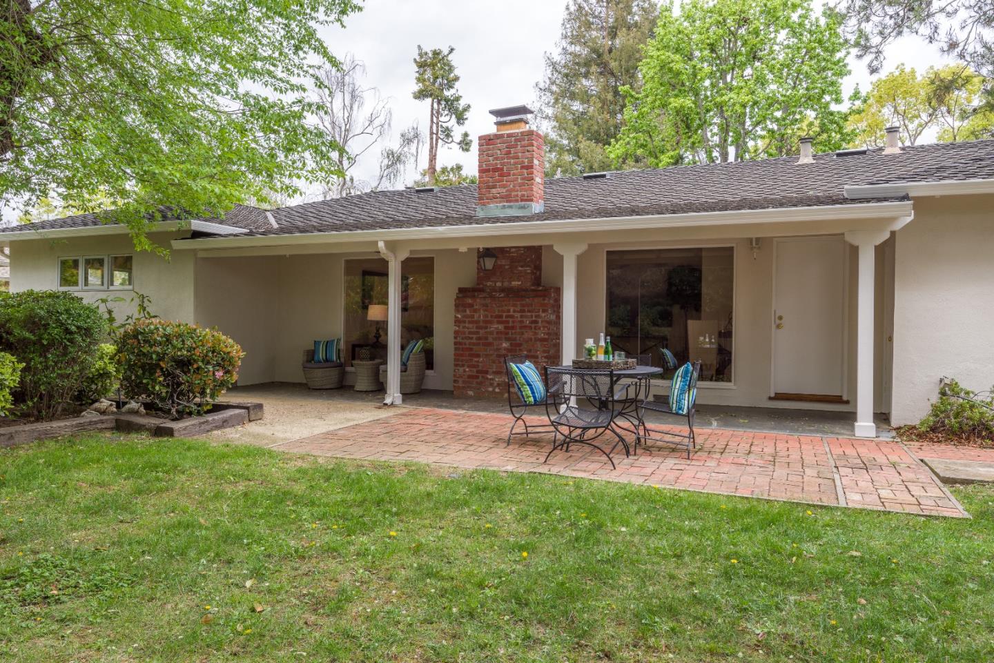 736 Filip Road Los Altos, CA 94024 - Photo 23 of 27 a view of a backyard with table and chairs potted plants and a large tree