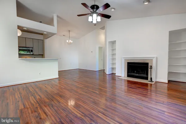 a view of a kitchen with a ceiling fan a fireplace and a ceiling fan