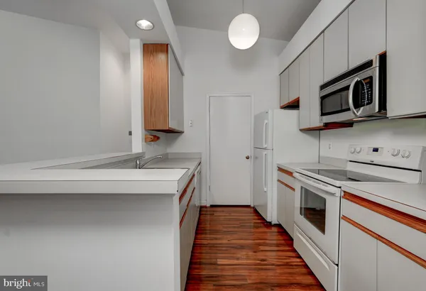 a kitchen with stainless steel appliances a stove microwave and sink