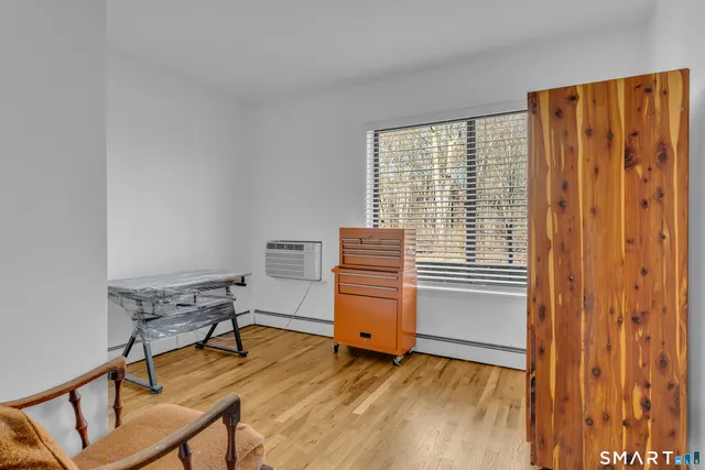 a bedroom with a chair and a window