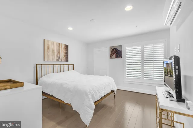 a bedroom with a bed and flat tv screen on the dresser
