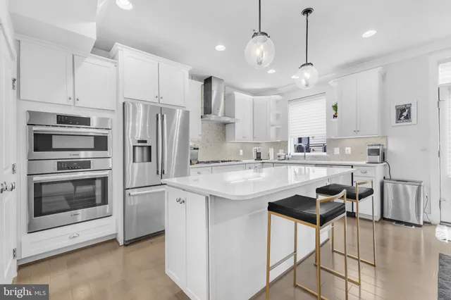 a kitchen with stainless steel appliances granite countertop a sink a stove a refrigerator and cabinets