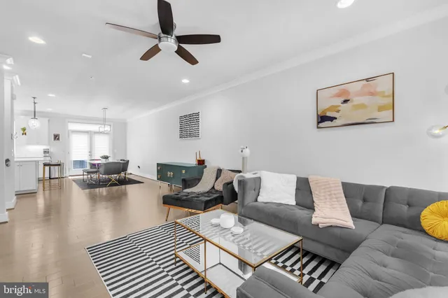 a living room with furniture and a view of kitchen