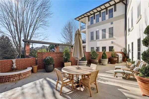 a view of a patio with couches table and chairs and potted plants