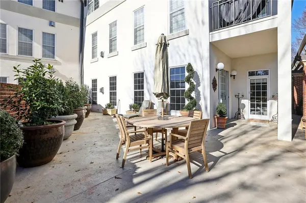 a view of a patio with table and chairs and potted plants