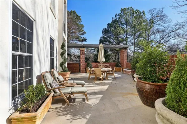 a view of a patio with chairs and potted plants