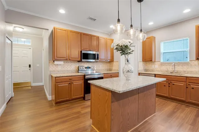 a kitchen with stainless steel appliances granite countertop a sink stove and refrigerator