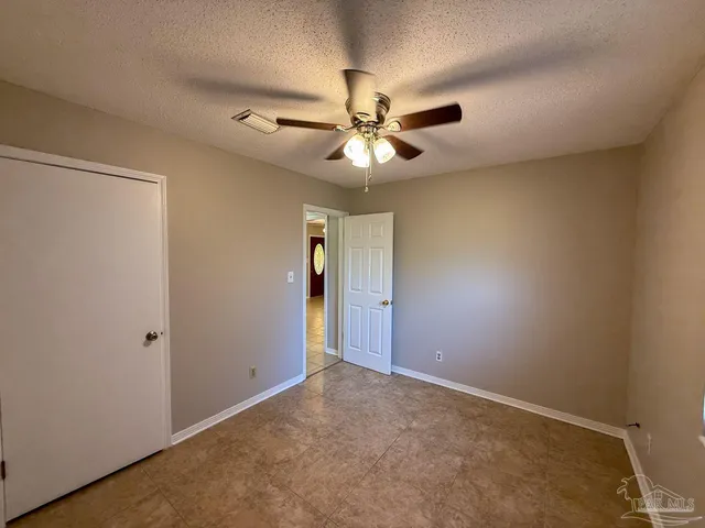 an empty room with closet and a chandelier fan