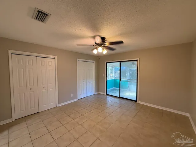 a view of an empty room with a ceiling fan