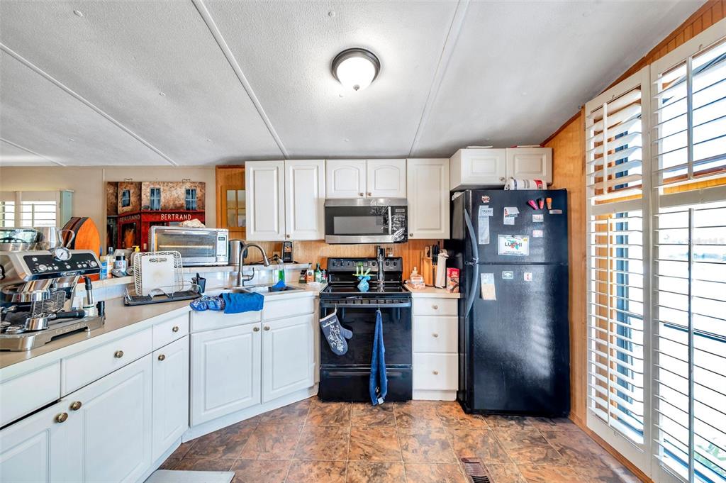 8844 Mike Street Port Richey, FL 34668 - Photo 19 of 51 a kitchen with refrigerator and window