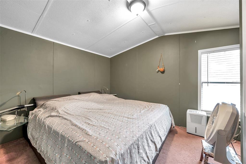 8844 Mike Street Port Richey, FL 34668 - Photo 28 of 51 a bedroom with a bed and a chair