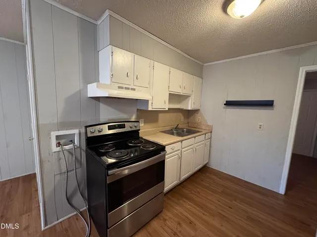 a kitchen with granite countertop a sink cabinets and stainless steel appliances