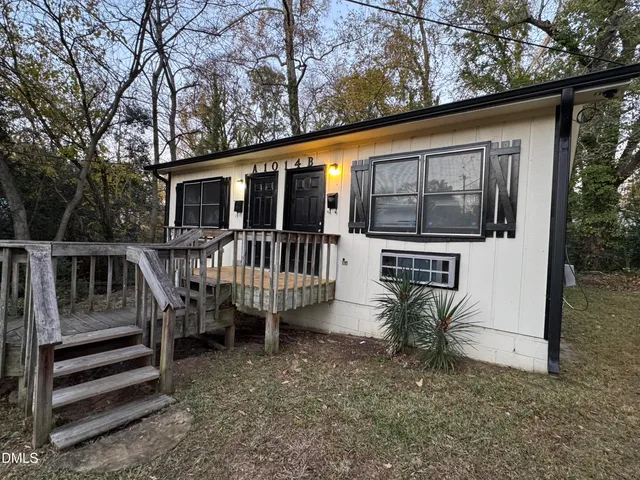 a view of a house with backyard and deck