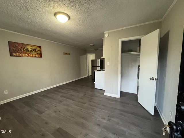 a view of empty room with wooden floor