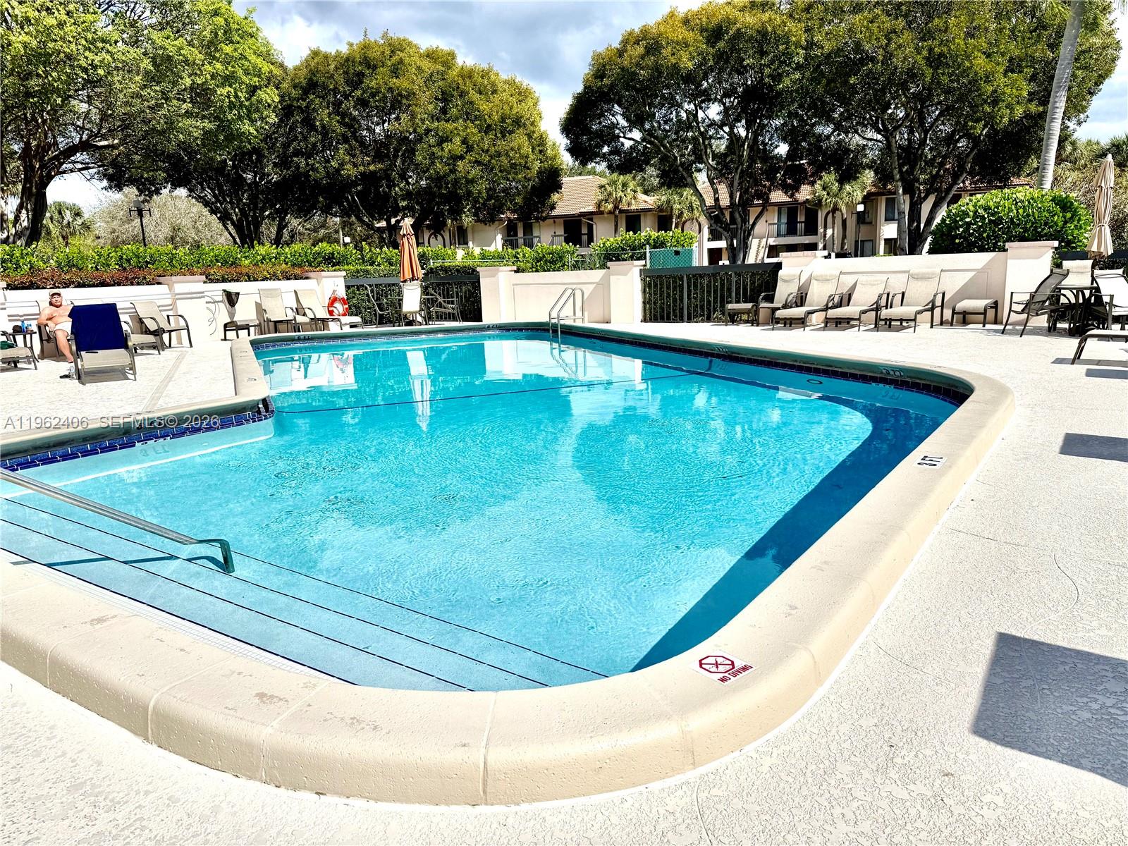 351 Club Circle, Unit 102 Boca Raton, FL 33487 - Photo 31 of 34 a view of a swimming pool with a patio and trees