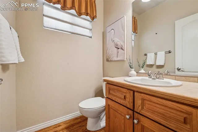 a bathroom with a granite countertop toilet sink and mirror