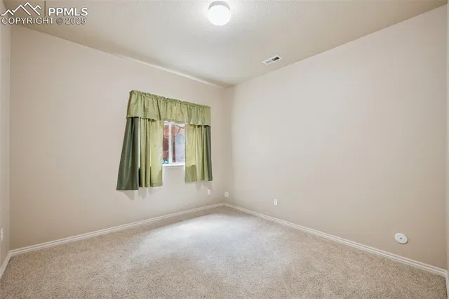 an empty room with a window and mirror