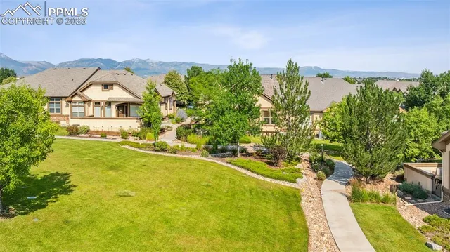 a view of a house with a big yard and large trees