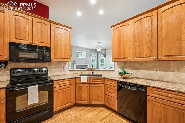 a kitchen with stainless steel appliances granite countertop a stove a sink dishwasher and a microwave oven with cabinets
