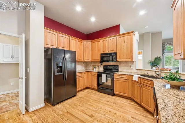 a kitchen with stainless steel appliances granite countertop a refrigerator a stove top oven a sink and dishwasher