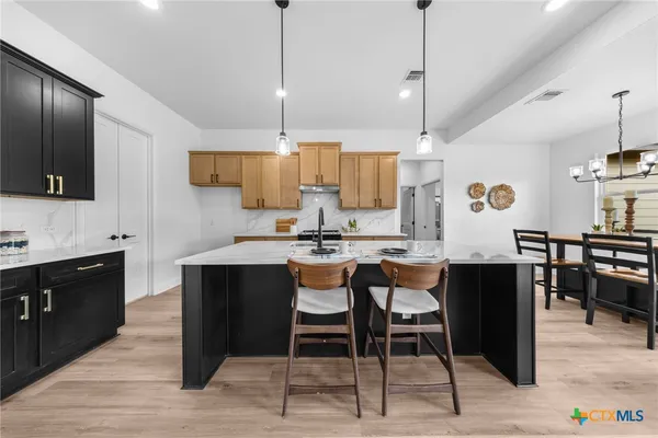 a kitchen with a table chairs refrigerator and microwave