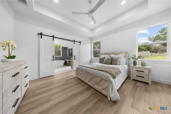 a spacious bedroom with a bed and a dresser
