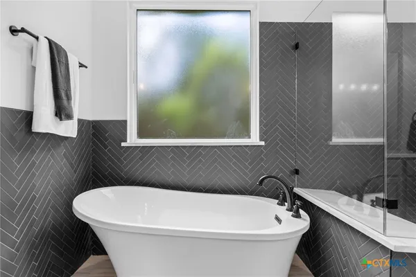 a white bath tub sitting next to a white sink and vanity
