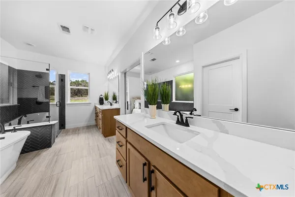 a bathroom with a sink a large mirror and a bathtub