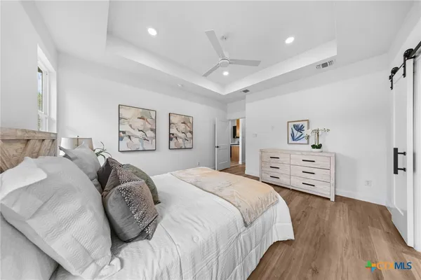 a spacious bedroom with a bed and a wooden floor