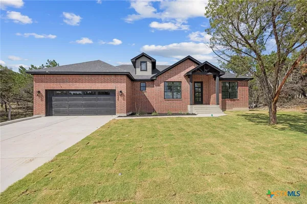 a front view of a house with yard and garage