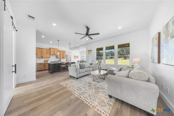 a living room with lots of furniture and view of kitchen