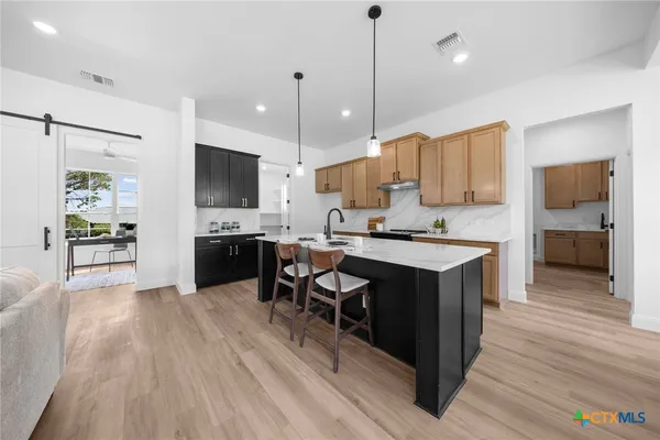 a large kitchen with lots of counter space a sink appliances and a center