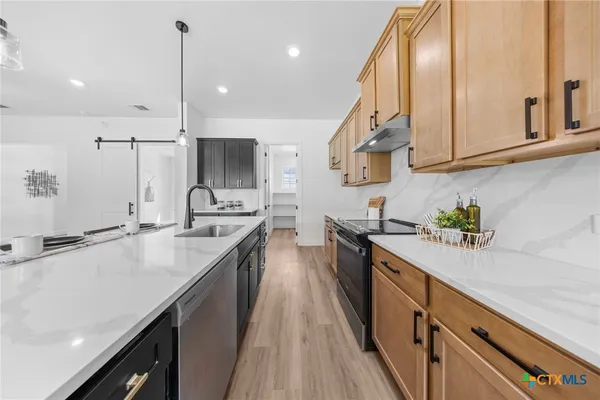 a kitchen with stainless steel appliances a sink stove and cabinets