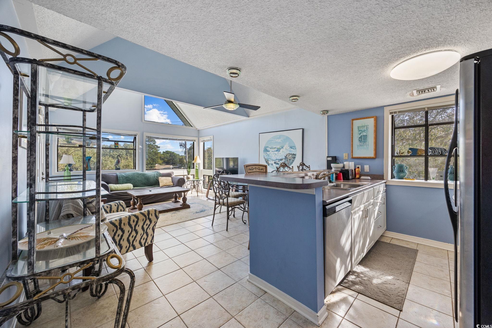 351 Lake Arrowhead Road, Unit 1301 Myrtle Beach, SC 29572 - Photo 11 of 40 Kitchen featuring a peninsula, dark countertops, stainless steel appliances, a textured ceiling, and lofted ceiling