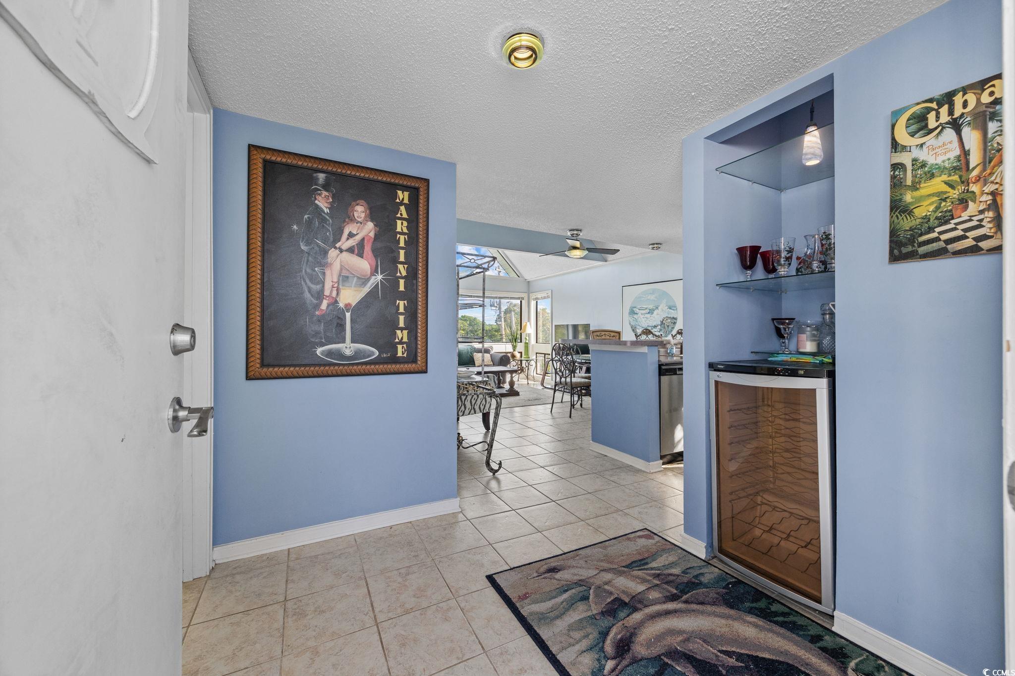 351 Lake Arrowhead Road, Unit 1301 Myrtle Beach, SC 29572 - Photo 8 of 40 Hallway with wine cooler, light tile patterned flooring, and a textured ceiling