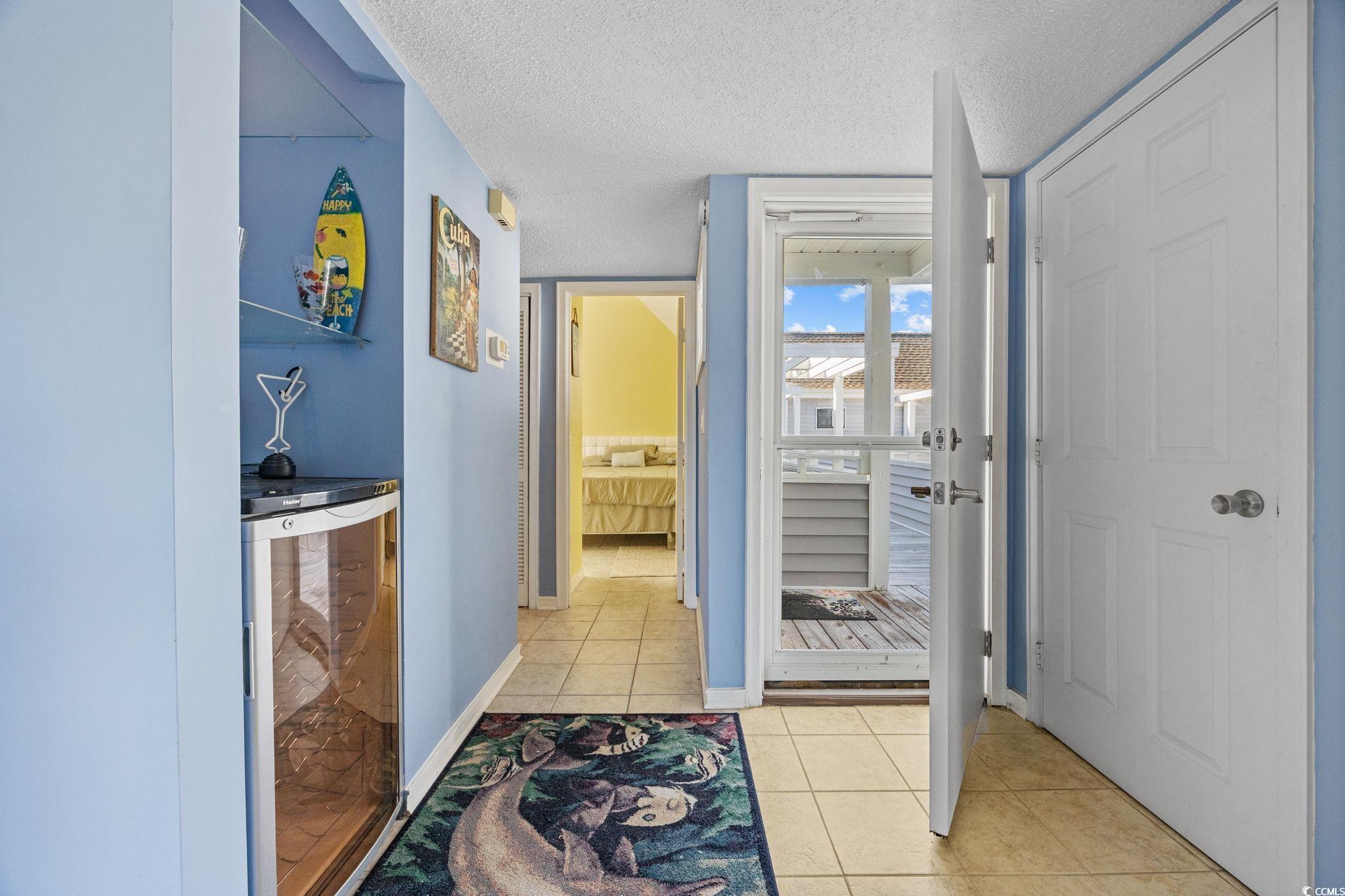 351 Lake Arrowhead Road, Unit 1301 Myrtle Beach, SC 29572 - Photo 9 of 40 Hall featuring light tile patterned floors, a textured ceiling, and wine cooler