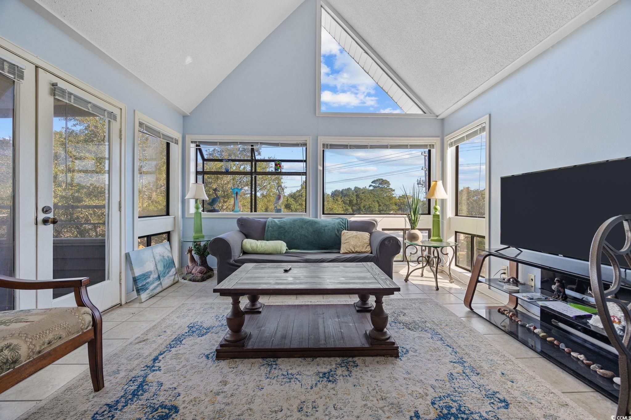 351 Lake Arrowhead Road, Unit 1301 Myrtle Beach, SC 29572 - Photo 10 of 40 Sunroom with a textured ceiling, high vaulted ceiling, tile patterned floors, and french doors