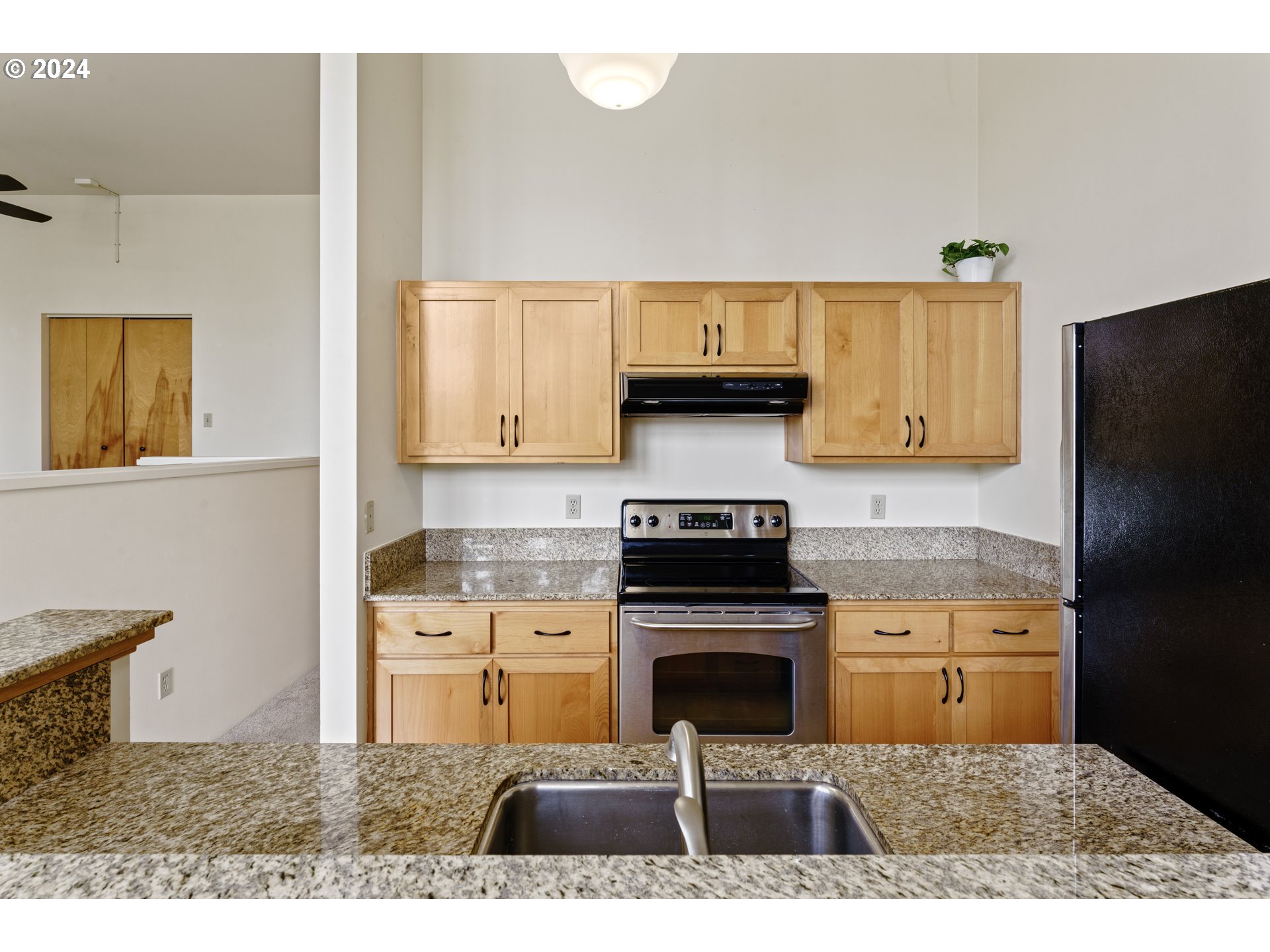 650 West 12th Avenue, Unit 202 Eugene, OR 97402 - Photo 11 of 30 a kitchen with stainless steel appliances granite countertop a stove a refrigerator and a sink