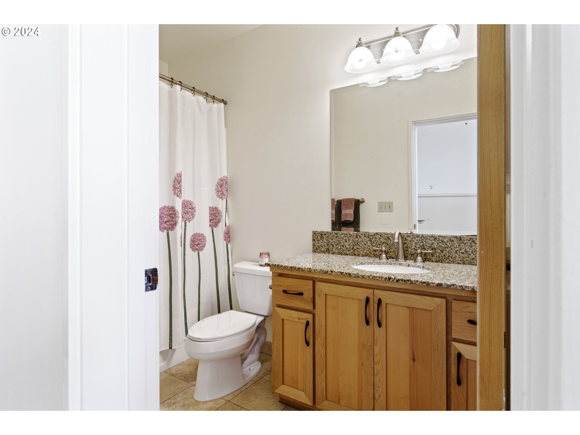 650 West 12th Avenue, Unit 202 Eugene, OR 97402 - Photo 16 of 30 a bathroom with a granite countertop sink toilet a mirror and shower curtain