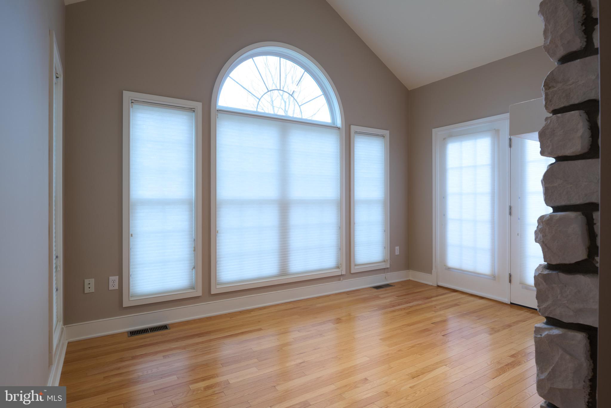 3222 Shellers Bend, Unit 209 State College, PA 16801 - Photo 13 of 76 an empty room with wooden floor mirror and windows