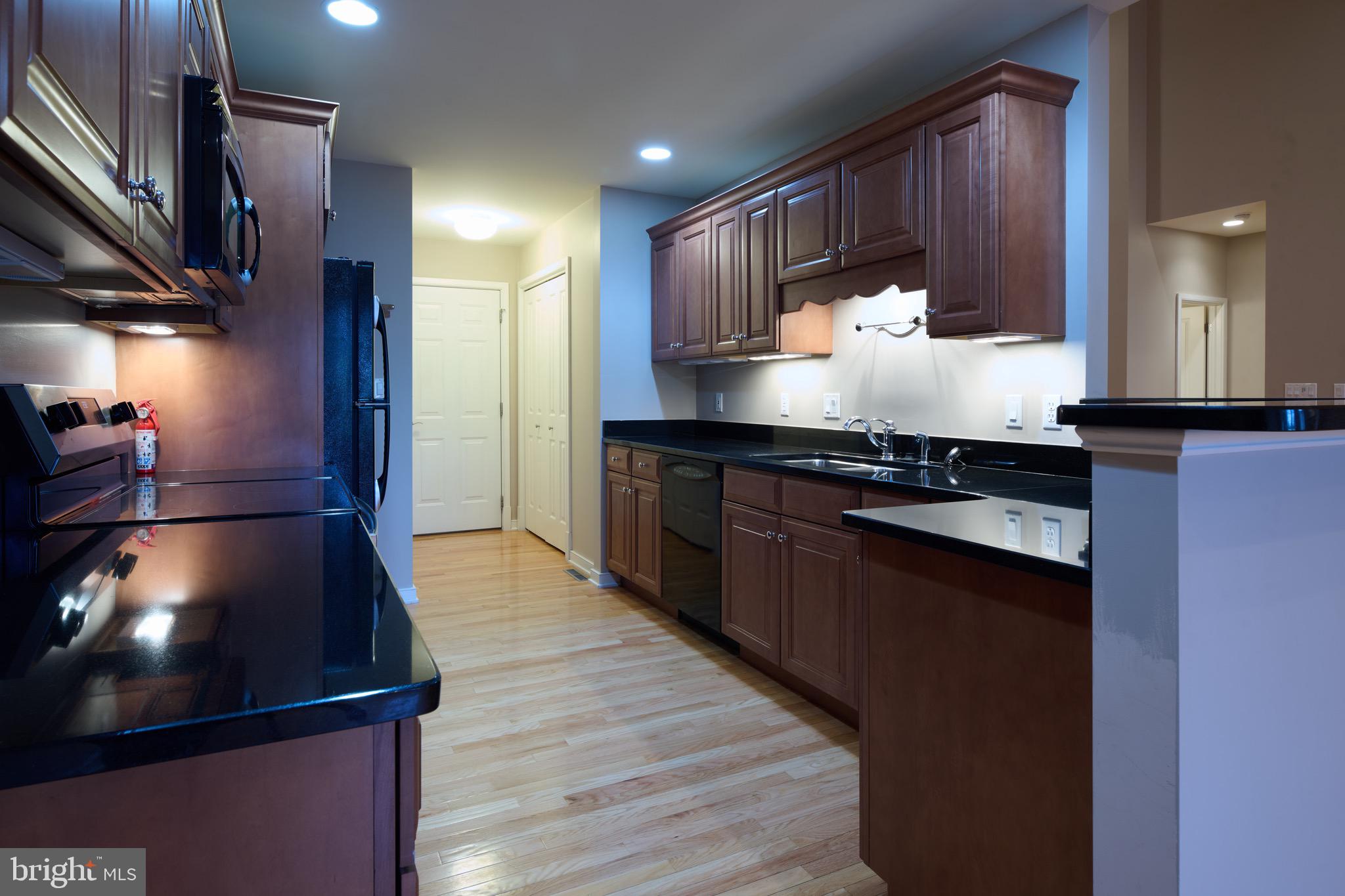 3222 Shellers Bend, Unit 209 State College, PA 16801 - Photo 19 of 76 a kitchen with stainless steel appliances granite countertop a stove a refrigerator a sink and wooden cabinets