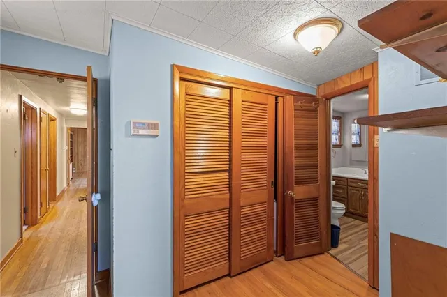 a view of a hallway with wooden floor and closet