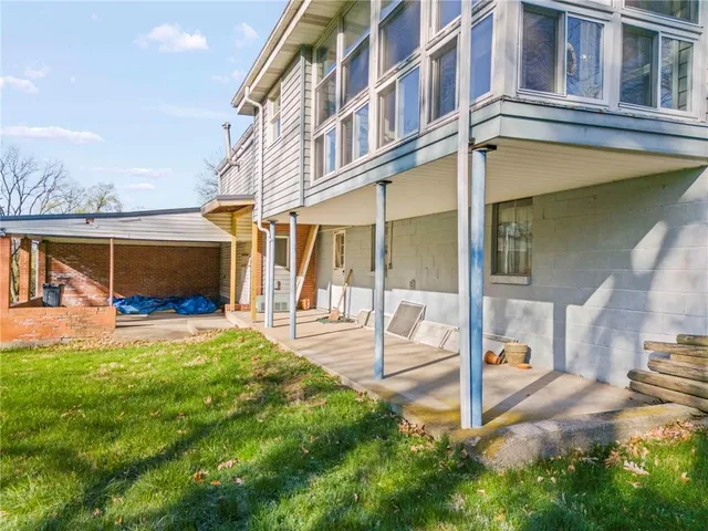 a view of a house with a big yard and large trees