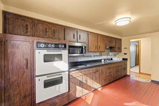 a kitchen with stainless steel appliances granite countertop a refrigerator and a stove top oven