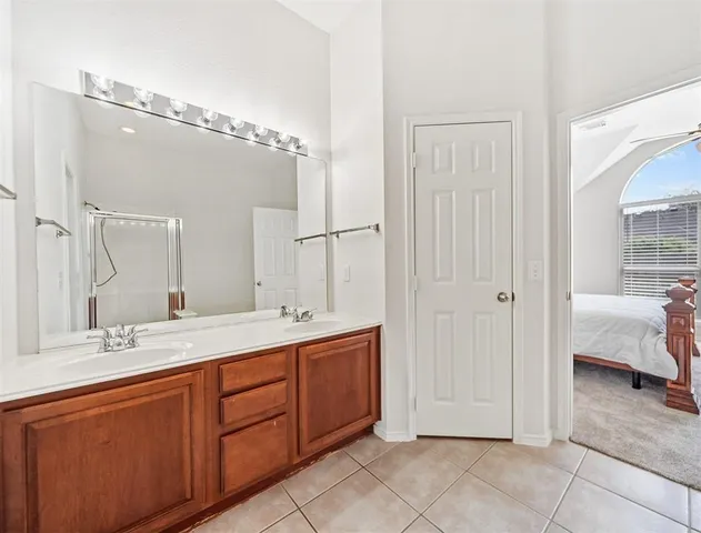 a spacious bathroom with a double vanity sink mirror and shower
