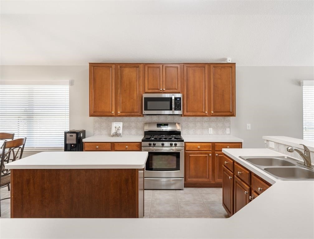19715 Youpon Leaf Way Houston, TX 77084 - Photo 9 of 20 a kitchen with stainless steel appliances granite countertop a sink stove and microwave