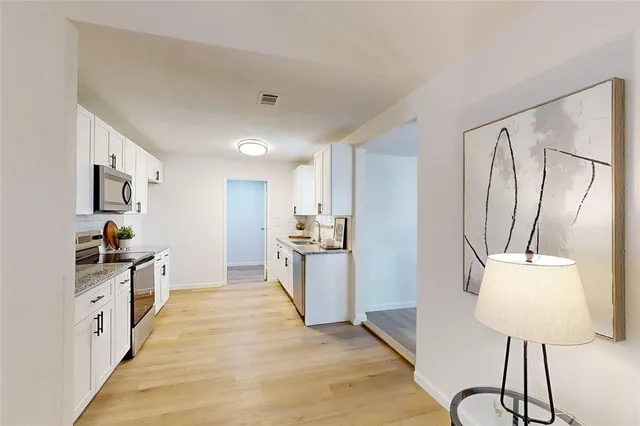 a kitchen with stainless steel appliances granite countertop a stove top oven a sink and dishwasher