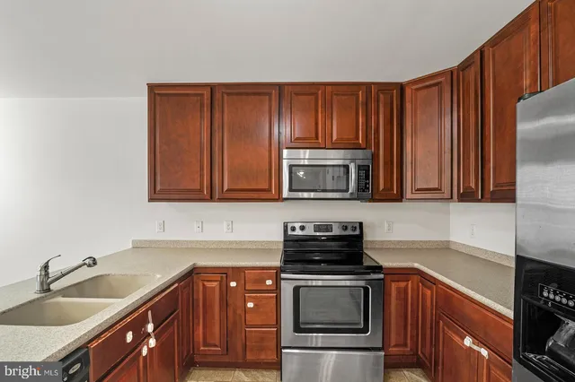 a kitchen with stainless steel appliances granite countertop a sink stove and microwave
