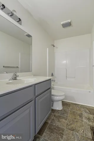 a bathroom with a granite countertop toilet a sink and a bathtub