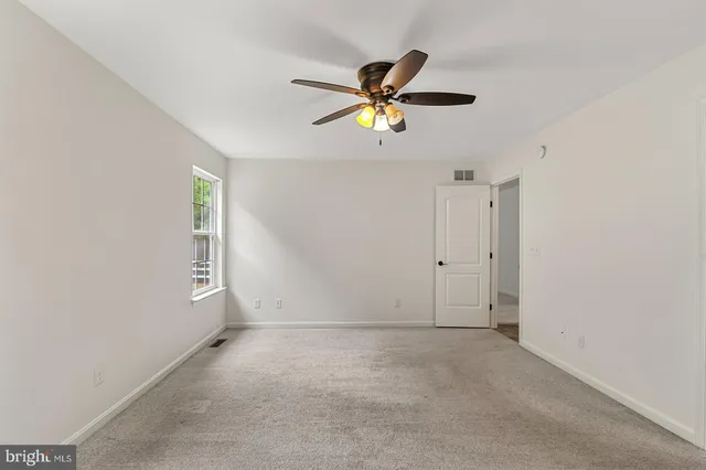 a view of a livingroom with a ceiling fan and window